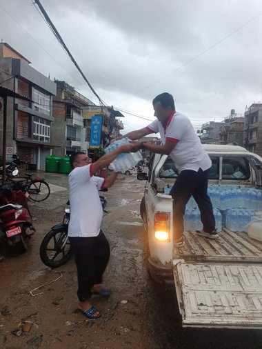 Rotkreuzmitarbeiter in Nepal laden Wasser vom Truck