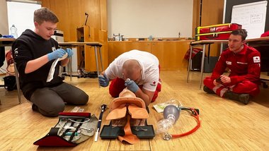 Mark Köckeis (Mitte) trainiert mit Sanitäter:innen die Assistenzmaßnahmen während einer endotrachealen Intubation.