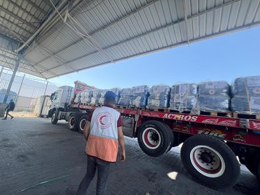 © Palestine Red Crescent Society Ein LKW mit Hilfslieferungen, davor ein Mitarbeiter des Palästinensischen Roten Halbmonds