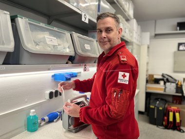 Ein Mitarbeiter in Rettungsdienstuniform überprüft die Funktionstüchtigkeit einer Absaugeinheit.