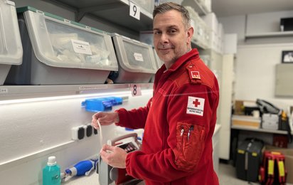 Ein Mitarbeiter in Rettungsdienstuniform überprüft die Funktionstüchtigkeit einer Absaugeinheit.