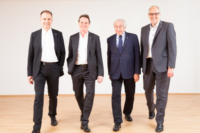 Foto der Geschäftsleitung und des Präsidenten des Roten Kreuzes. Sie gehen auf die Kamera zu.
