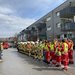 Feuerwehrleute und Rotkreuz-Sanitäter:innen stehen gemeinsam vor dem Seniorenwohnhaus Hallwang