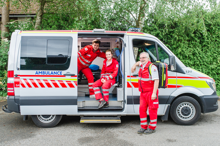 Sanitäter:innen in und vor einem Rettungswagen des Roten Kreuz Salzburgs
