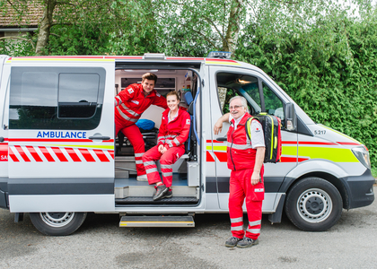 Ein Sanitäter schaut aus dem Rettungsauto, eine Sanitäter ebenso, ein Sanitäter steht vor dem Auto.