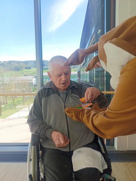 Der Osterhase übergibt einem Bewohner Geschenke