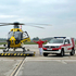 Leopold Hartl steht zwischen dem Notarzthubschrauber C10 und dem Notarzteinsatzfahrzeug