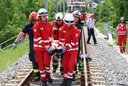 Ein Einsatzteam trägt einen Patienten auf den Gleisen