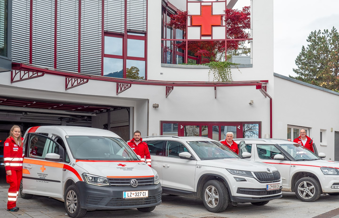 3 unterschiedliche RK-Transportfahrzeuge für die Gesundheits- und Sozialen Dienst stehen mit 4 RK-Mitarbeitern vor dem Gebäude der RK-Bezirksstelle Osttirol