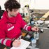 Ein Mann in Rotkreuz-Jacke analysiert eine Wasserprobe