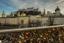 Salzburger Altstadt mit Festung Hohensalzburg vom Marko-Feingold-Steg aus fotografiert. Im Vordergrund die am Steg befestigten Liebesschlösser.