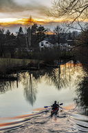 Ein Kanufahrer, der bei Sonnenuntergang in einem Fluss paddelt
