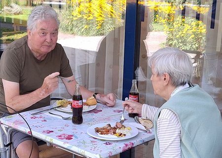 Zwei Bewohnerinnen des Seniorenwohnhaues sitzen gemeinsam am Tisch und essen