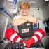 Zivildiener Alexander sitzt auf der Trage im Rettungsauto und hält einen Defibrillator in der Hand.