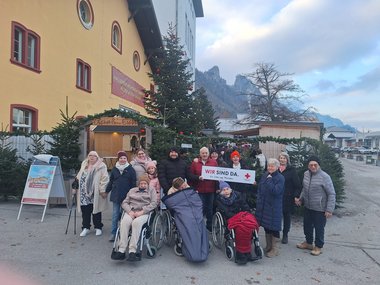Eine Gruppe mit Pflegekräften und Bewohner:innen des Seniorenwohnhauses Hallein am Christkindlmarkt.