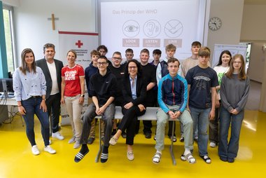 Das Jugendrotkreuz Salzburg bietet gemeinsam mit dem Land Salzburg Workshops zu „Psychischer Erste Hilfe“ für Schüler:innen in Salzburg an. (v.l.n.r.) Caroline Lamprecht (Workshopleiterin), Anton Lettner (Landesleiter des Jugendrotkreuzes Salzburg), Andrea Neuhofer (Operative Leiterin, Jugendrotkreuz Salzburg) und die teilnehmenden Schüler:innen.