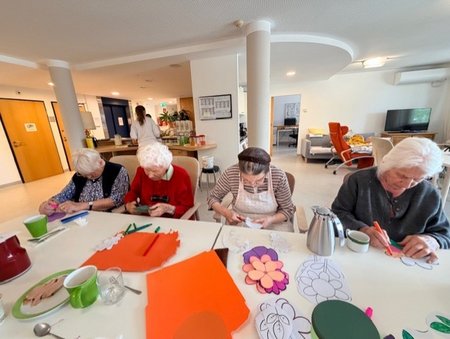 Bewohnerinnen des Seniorenwohnhauses helfen bei der Gestaltung der Wände mit.