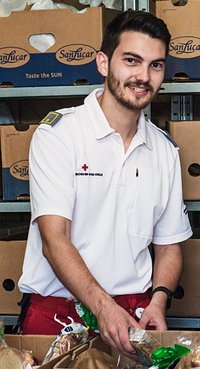 Ein Mitarbeiter des Roten Kreuzes bei der Lebensmittelausgabe
