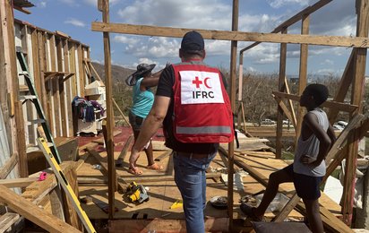 Mitarbeiter der IFRC in einem zerstörten Haus in Jamaika