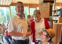 Eine Reiseteilnehmerin mit zwei Rotkreuz-Mitarbeiter:innen, alle lachen herzlich