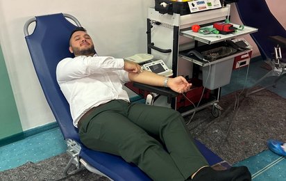 Ein Mann liegt auf einer Blutspendeliege und spendet Blut.