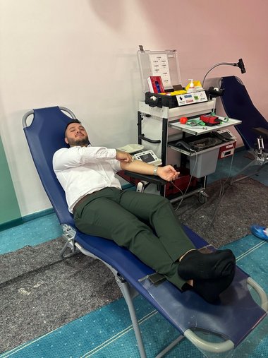 Ein Mann liegt auf einer Blutspendeliege und spendet Blut.