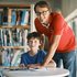 Ein Pädagoge in RK T-Shirt und ein Schüler in einer Bibliothek