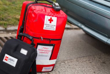 © ÖRK/Thomas Holly Kellner Der Notfallrucksack eines First Responders steht am Boden neben einem Auto.