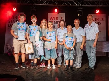 Die Sieger-Jugendgruppe der Kategorie Jugend 1: „Rescue Sharks 2“ aus Saalfelden mit Emily Eder, Bewerbsleiterin, Isabella Pernthaner-Schneider, Bezirksgeschäftsführerin Pinzgau, Michael Hinterhofer, Landesreferent, Dr. Werner Aufmesser, RK-Präsident.