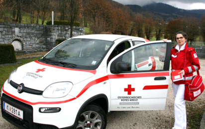 Mitarbeiterin vor Rotkreuz-Auto