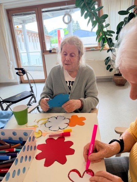 Bewohnerinnen des Seniorenwohnhauses helfen bei der Gestaltung der Wände mit.