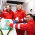 Drei Rettungssanitäter in Uniform mit Adventkalender im Rettungsauto