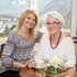 Zwei Frauen sitzen gemeinsam an einem kleinen Tisch.