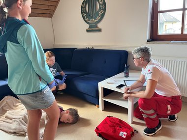 Gruppe bei Station mit bewusstlosem Kind