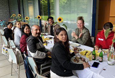 Mitarbeiter:innen des Seniorenwohnhauses Hallein sitzen gemeinsam an einem Tisch und essen