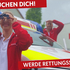 Rettungssanitäterin steht vor einem Rettungsauto und schaut durch ein Fernglas