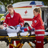 Ein Zivildiener und eine Mitarbeiterin im freiwilligen Sozialjahr betreuen eine Patientin auf der Trage.