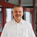 Porträt von Herbert Girstmair, Bereichsleiter Rettungs- und Krankentransport, Ambulanzdienste. Er steht im weißen Hemd vom Roten Kreuz