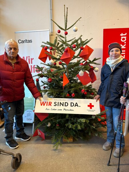 Ein Bewohner des Seniorenwohnhauses Hallein mit einem Kind einer Pflegekraft am Christkindlmarkt.