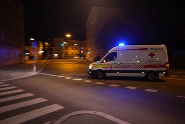 Ein nachts im Einsatz befindlicher Rettungswagen des Roten Kreuzes, der in das Gelände des Landeskrankenhauses Salzburg einbiegt.