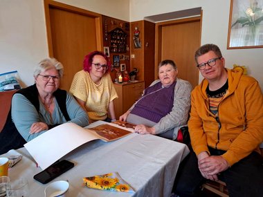 Vier Personen sitzen an einem Tisch