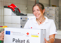 © Rotes Kreuz Graz-Stadt/ D. Hackinger Elisa Muhr bei der Übergabe eines Schulstartpaketes.