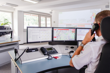 Leitstellenmitarbeiter an seinem Arbeitsplatz, telefoniert.