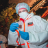 Eine Testperson führt einen Antigen-Test unter einer Discokugel durch