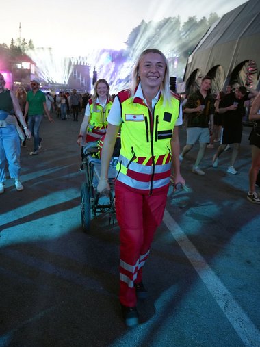 Zwei Rotkreuzsanitäterinnen bewegen sich in Uniform durch das Publikum am Electric-Love-Festival