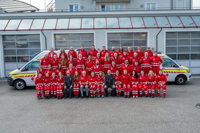 Gruppenbild der Mitarbeiterinnen der Rotkreuz-Dienststelle Hof vor zwei Rettungswägen