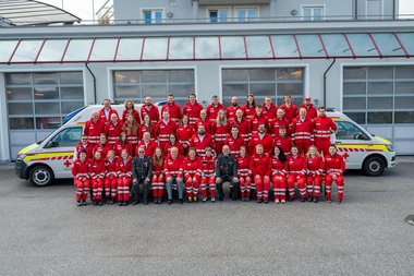 Gruppenbild der Mitarbeiterinnen der Rotkreuz-Dienststelle Hof vor zwei Rettungswägen