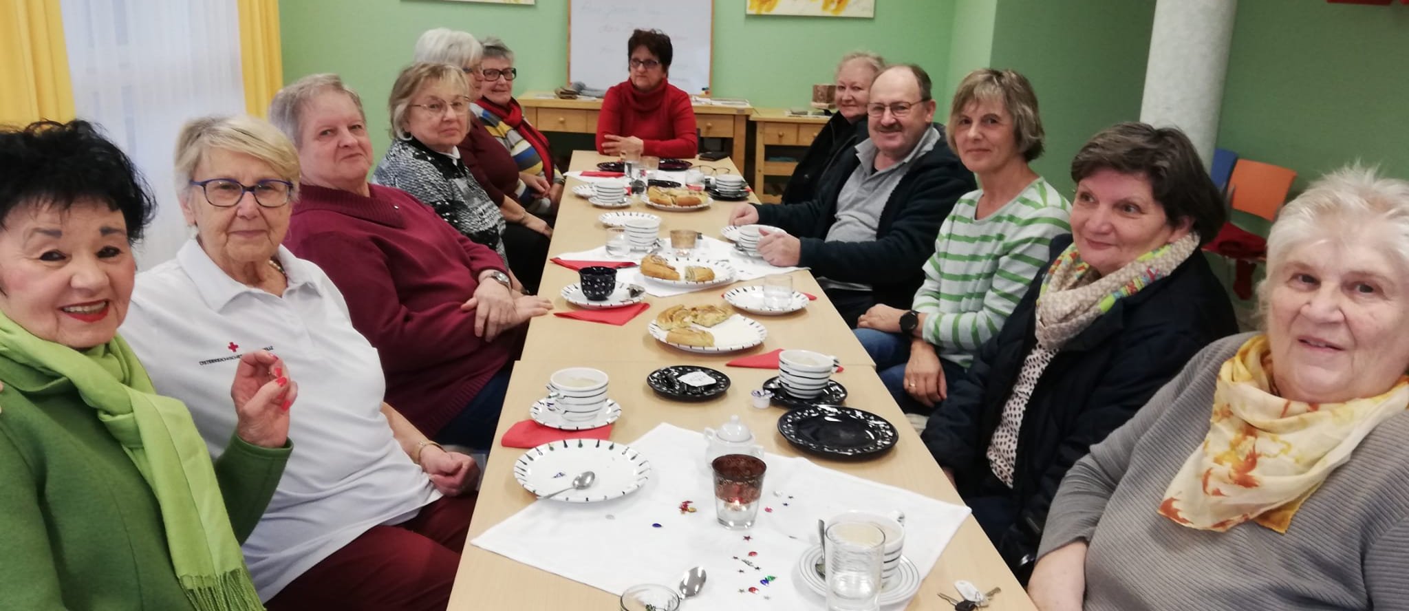 Besuchsdienstgruppe in Rossbach sitzt um eine lange Tafel
