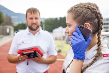 Eine Jugendliche ruft mit ihrem Mobiltelefon den Notruf 144