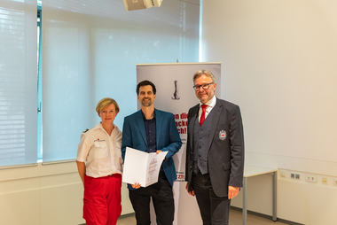 RK-Landesgeschäftsleiter-Stv. Dir. Mag. Thomas Märzinger und RK-Bezirksstellenleiterin Mag. Michaela Schwinghammer-Hausleithner gratulieren Dr. Stephan Mitterhauser zur Beförderung